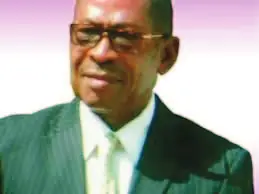 Portrait de Charlie Tchikanda, en costume et lunettes.