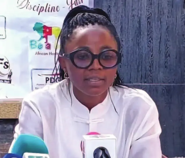 Une intervenante en conférence de presse devant les micros, lors de la signature de Nchout Ajara.