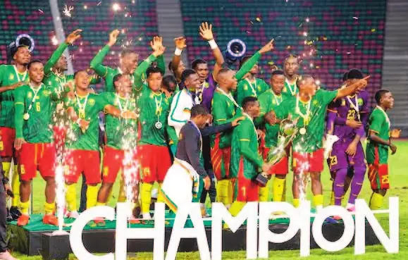 Les Lionceaux indomptables U20 célèbrent leur titre devant l’inscription « Champion ».