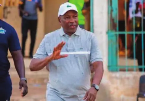 Malick Daf, entraîneur de Teungueth FC, en casquette au bord du terrain.
