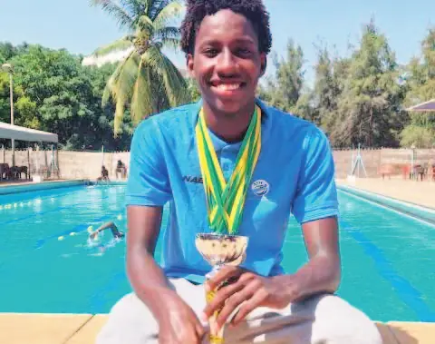 Naël Lamine Voisin, médaille autour du cou, au bord d’une piscine.