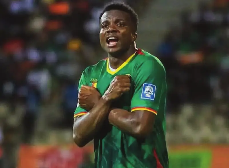 Nouhou Tolo, en maillot vert du Cameroun, les bras croisés sur la poitrine.