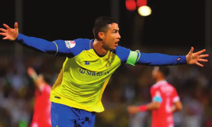 Cristiano Ronaldo, maillot jaune d’Al-Nassr, célèbre un but bras écartés.
