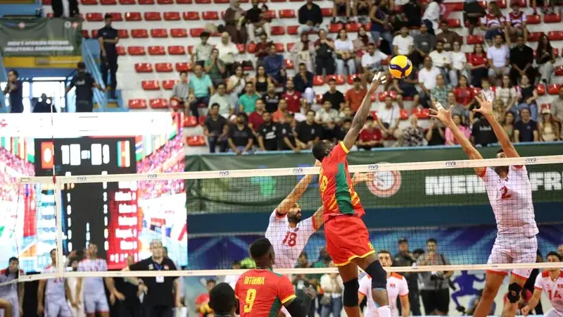Un joueur camerounais attaque au filet face au bloc tunisien lors de la finale à Tunis.